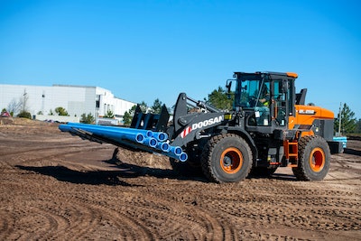 Doosan DL250-7 wheel loader carrying blue pipes building construction site