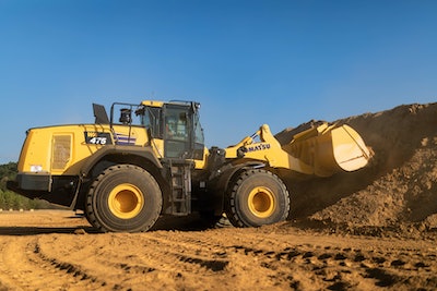 Komatsu WA475-10 wheel loader filling bucket in dirt pile