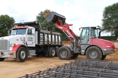 Takeuchi TW95 wheel loader with bucket ready to unload dirt in truck bed