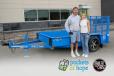 Joe Kostreba, auction winner, and Brenda Jennissen, Felling Trailers’ CEO with the 2023 Trailer for a Cause, a FT-3 utility trailer.