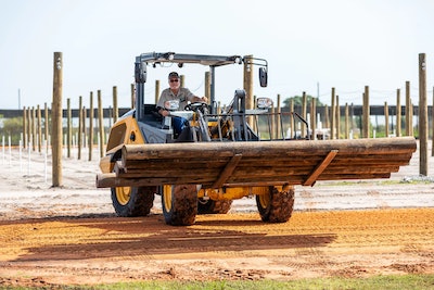 John Deere 184 G-Tier compact wheel loader hauling logs