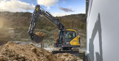 volvo ecr145 excavator digging beside wall