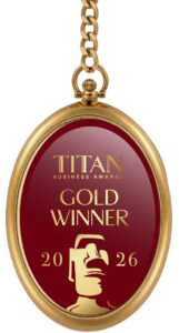 Gold Titan Business Awards pendant reading 'GOLD WINNER' for 2026, on a red background with a trophy icon and chain shows luxury.