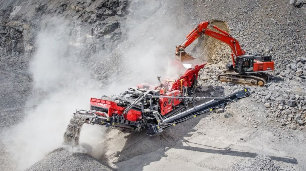Red rock-crushing and conveying machine at a dusty quarry slope in operation.