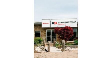 905x0_s3-71402-Cornerstone-Equipment_1jpg - Machines Wiki Exterior view of Cornerstone Equipment storefront with a Takeuchi sign, featuring a wooden walkway and a red-leaved tree in front.