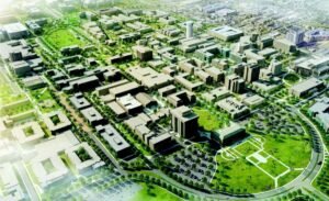 Aerial view of a modern urban campus with green spaces, rectangular buildings, and a circular parkway outline.