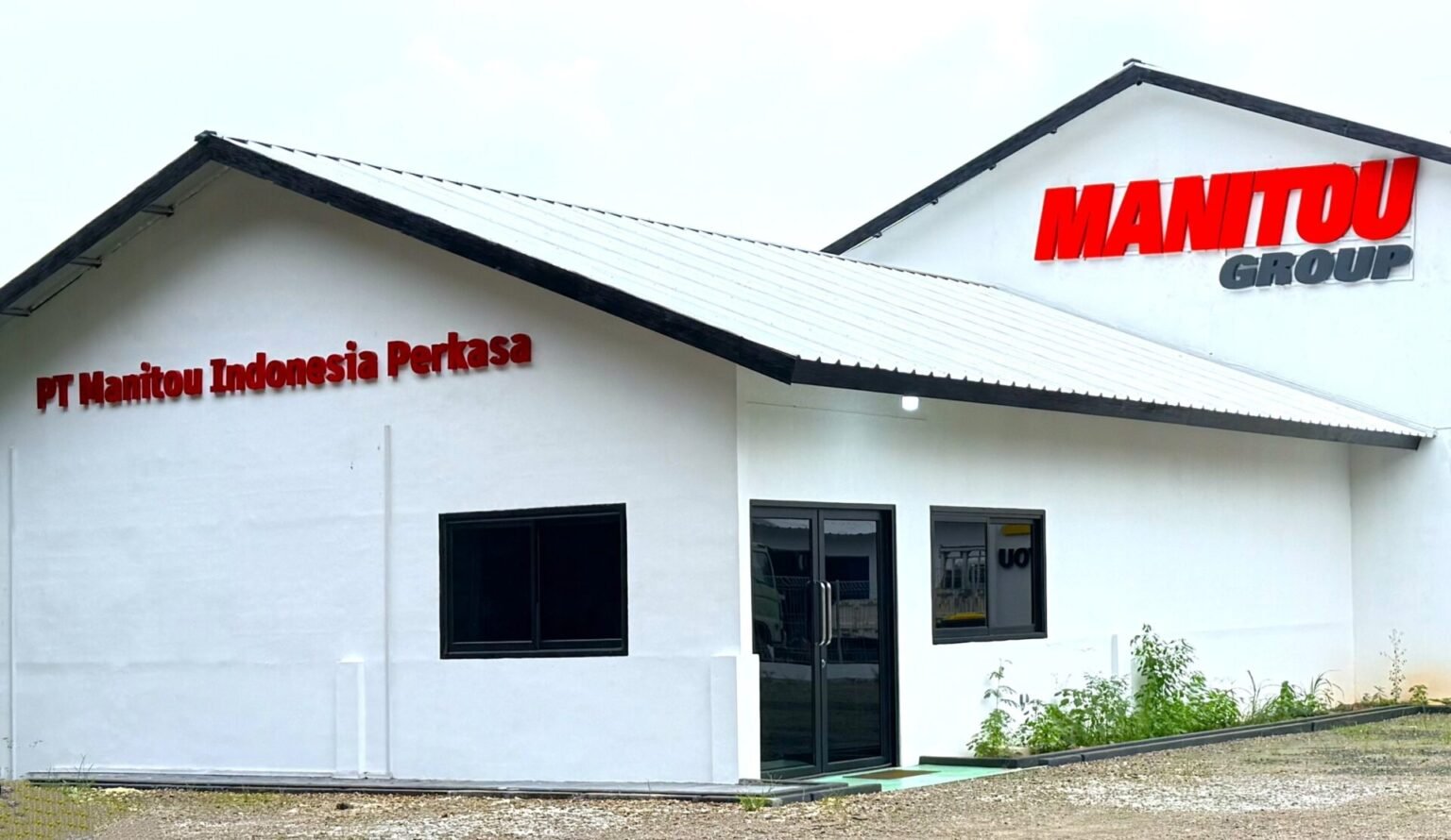 White industrial building with red 'MANITOU GROUP' sign on the roof and 'PT Manitou Indonesia Perkasa' lettering on the front wall