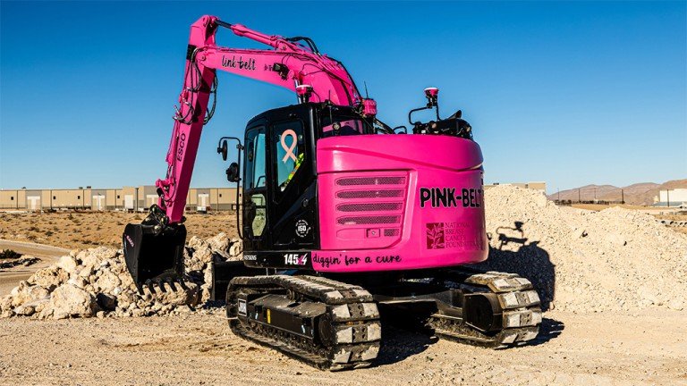 LBX donates Pink-Belt proceeds to breast cancer organizations Pink excavator at a construction site painted for breast cancer awareness with a ribbon decal and slogan 'diggin for a cure' on the side.