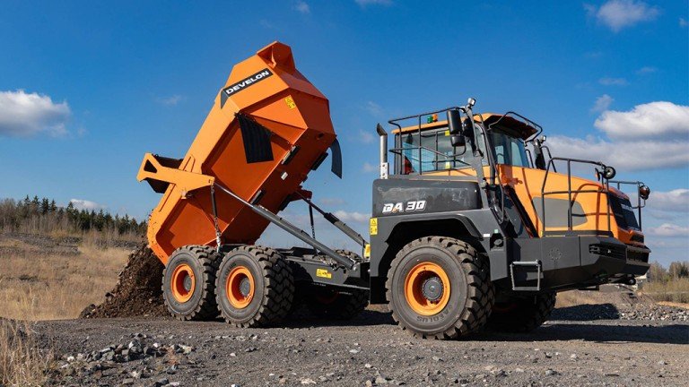 DEVELON’s Dash 7 updates extend to DA30 ADT Orange articulated dump truck dumping soil at a gravel quarry under a blue sky, rugged construction site scene