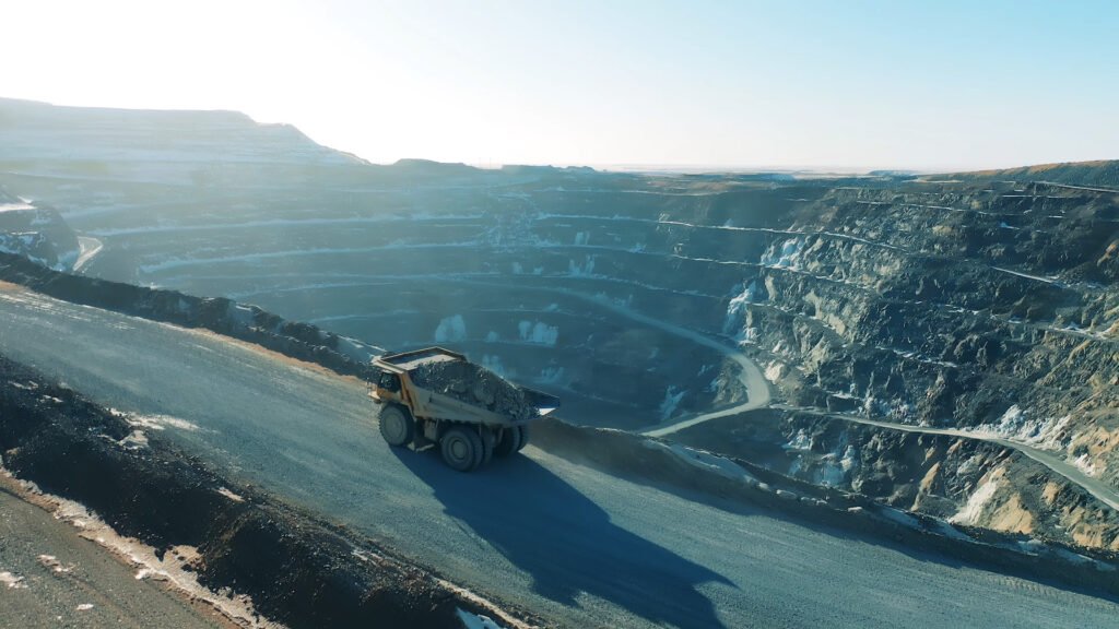 Epiroc Takes Autonomous Haulage Into Aggregates With Heidelberg Materials Quarry Project Open-pit mining site with a large dump truck on a winding road along terraced quarry walls at dusk/dawn light