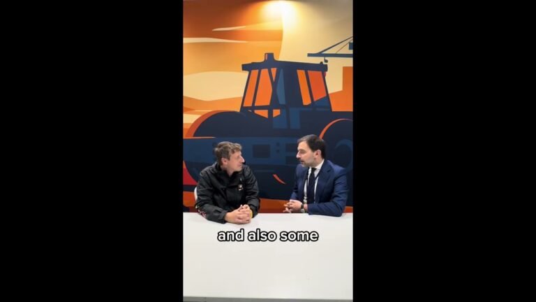 maxresdefault-3jpg - Machines Wiki Two men in a discussion sit at a white table against a bold orange and blue industrial mural; caption reads 'and also some' at bottom.
