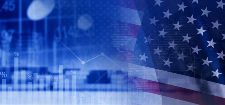 Blue composite image with financial charts and percent markers overlaid on a waving U.S. flag, symbolizing US economic data analysis.