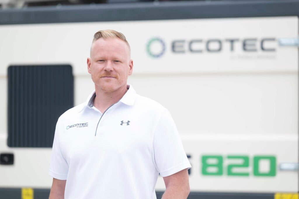 Ecotec Strengthens Global Sales Team With Christopher Pickhardt Appointment Portrait of a man in a white polo outdoors beside an ECOTEC-branded building.