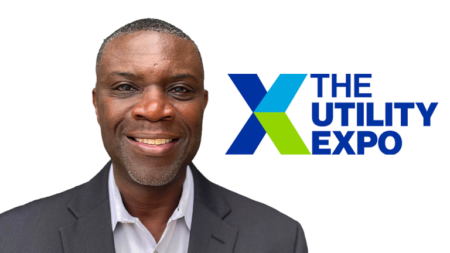 Smiling man in a suit beside the The Utility Expo logo on a white background.