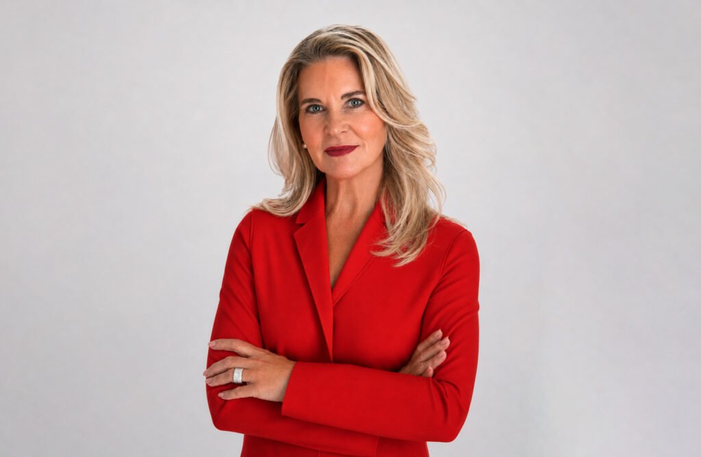 VitalEdge Appoints Theresa Thomas as Executive Vice President of Strategic Partnerships Professional woman with blonde hair in a red blazer, arms crossed, looking at the camera.