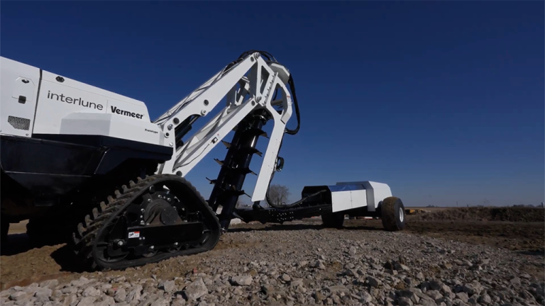 1785880087_64136_en_21e5d_66316_vermeer-interline-excavatorpng - Machines Wiki White excavator with a long articulated arm and tracked undercarriage on a rocky construction site under a clear blue sky