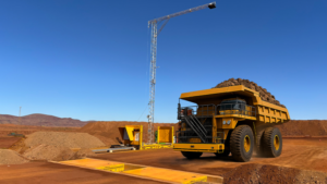 1786089930_64153_en_e6c02_66337_kal-tire-trasncale-agreementpng - Machines Wiki Large yellow mining dump truck at a quarry with a crane and dirt piles under a clear blue sky