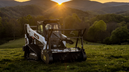 1787004038_64168_en_79db0_66358_bobcat-t86-2-land-management-packagepng - Machines Wiki Tracked loader sits on a grassy field at sunset with rolling hills in the background.