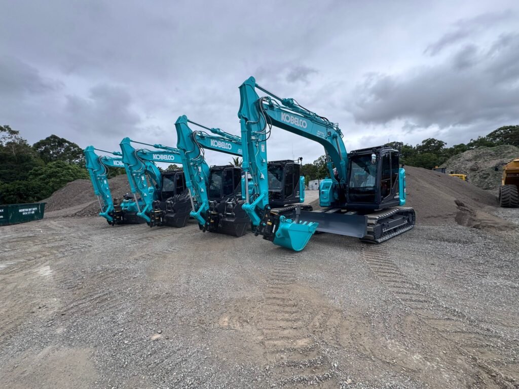 Late-model Kobelco excavators lined up in the earth gear yard, ready for civil dry hire mobilisation.